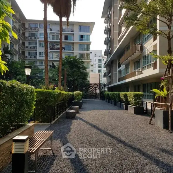 Modern apartment complex with lush greenery and outdoor seating area
