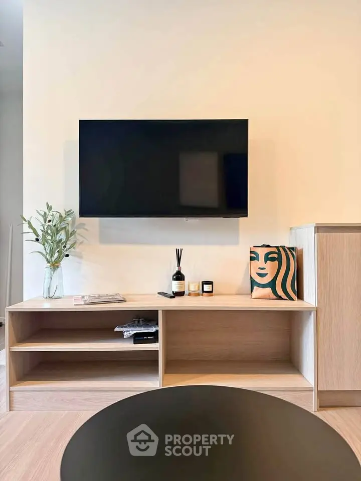 Modern living room with wall-mounted TV and stylish wooden cabinet, perfect for contemporary living.