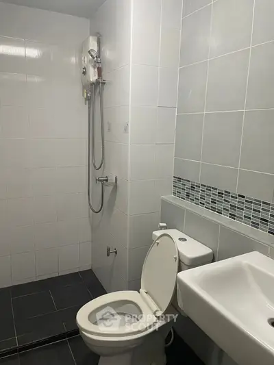 Modern bathroom with sleek tiles and shower in a contemporary apartment.
