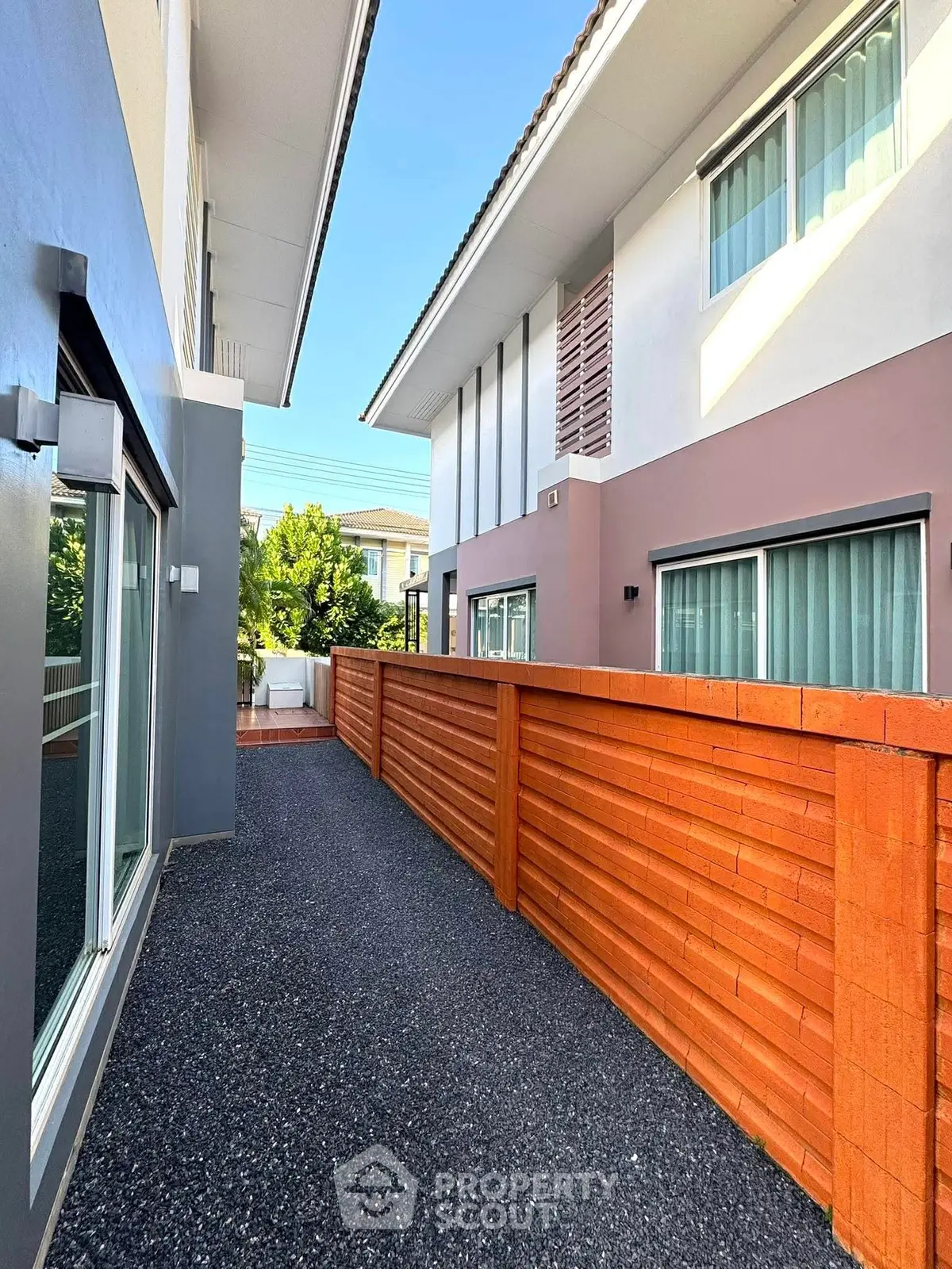 Modern townhouse exterior with sleek design and wooden fence, perfect for urban living.