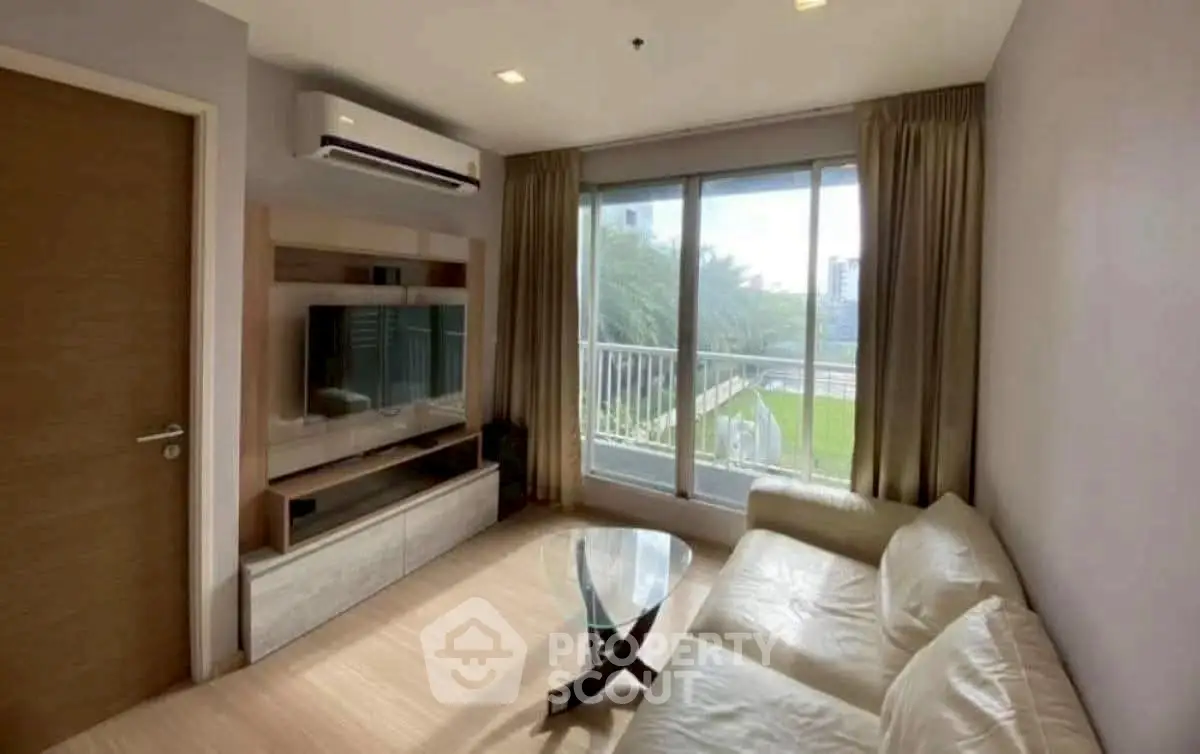 Modern living room with large window and sleek furniture, offering a bright and inviting atmosphere.
