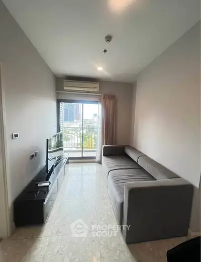 Modern living room with sleek sofa and city view from window, perfect for urban living.