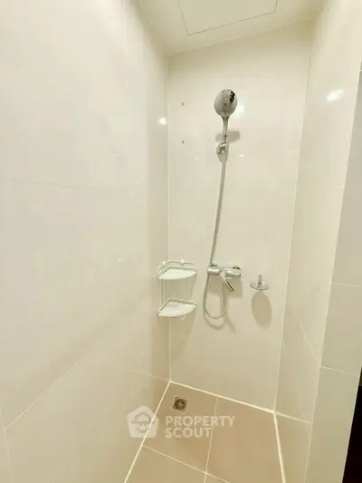 Modern minimalist shower area with sleek white tiles and chrome fixtures