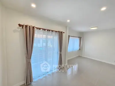 Spacious and bright living room with large windows and elegant curtains