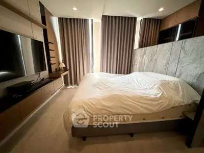 Luxurious bedroom with modern design, featuring a large bed, stylish curtains, and sleek wooden accents.