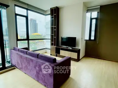 Modern living room with purple sofa and city view through large windows