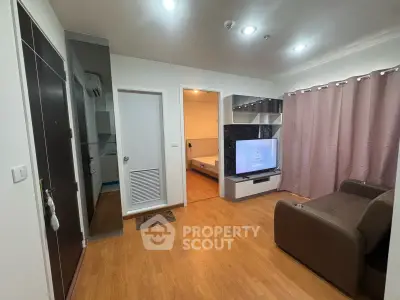 Modern living room with wooden flooring, cozy sofa, and wall-mounted TV in a stylish apartment.