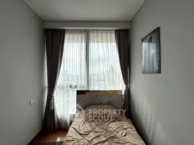 Cozy bedroom with large window and city view, perfect for urban living.