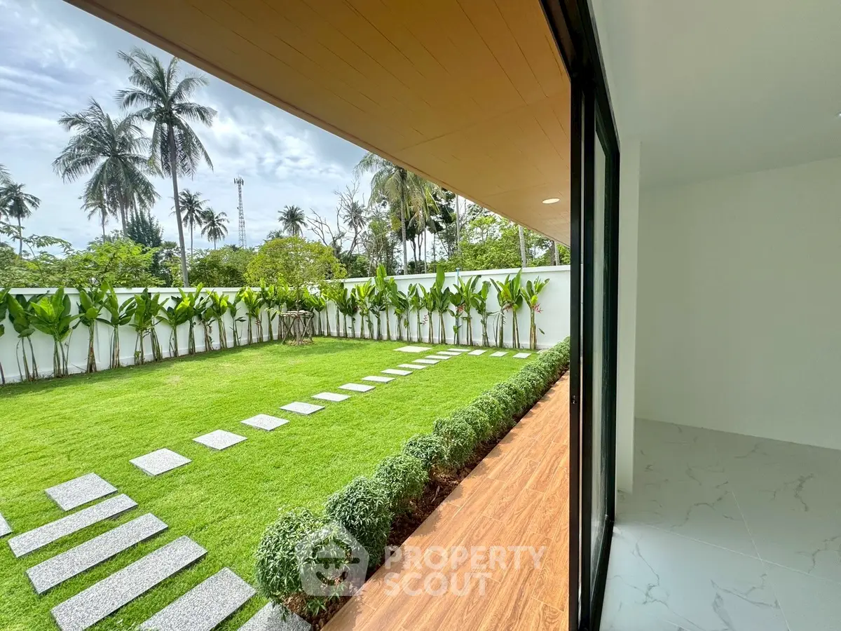 Luxurious garden view from modern home with spacious patio and lush greenery.