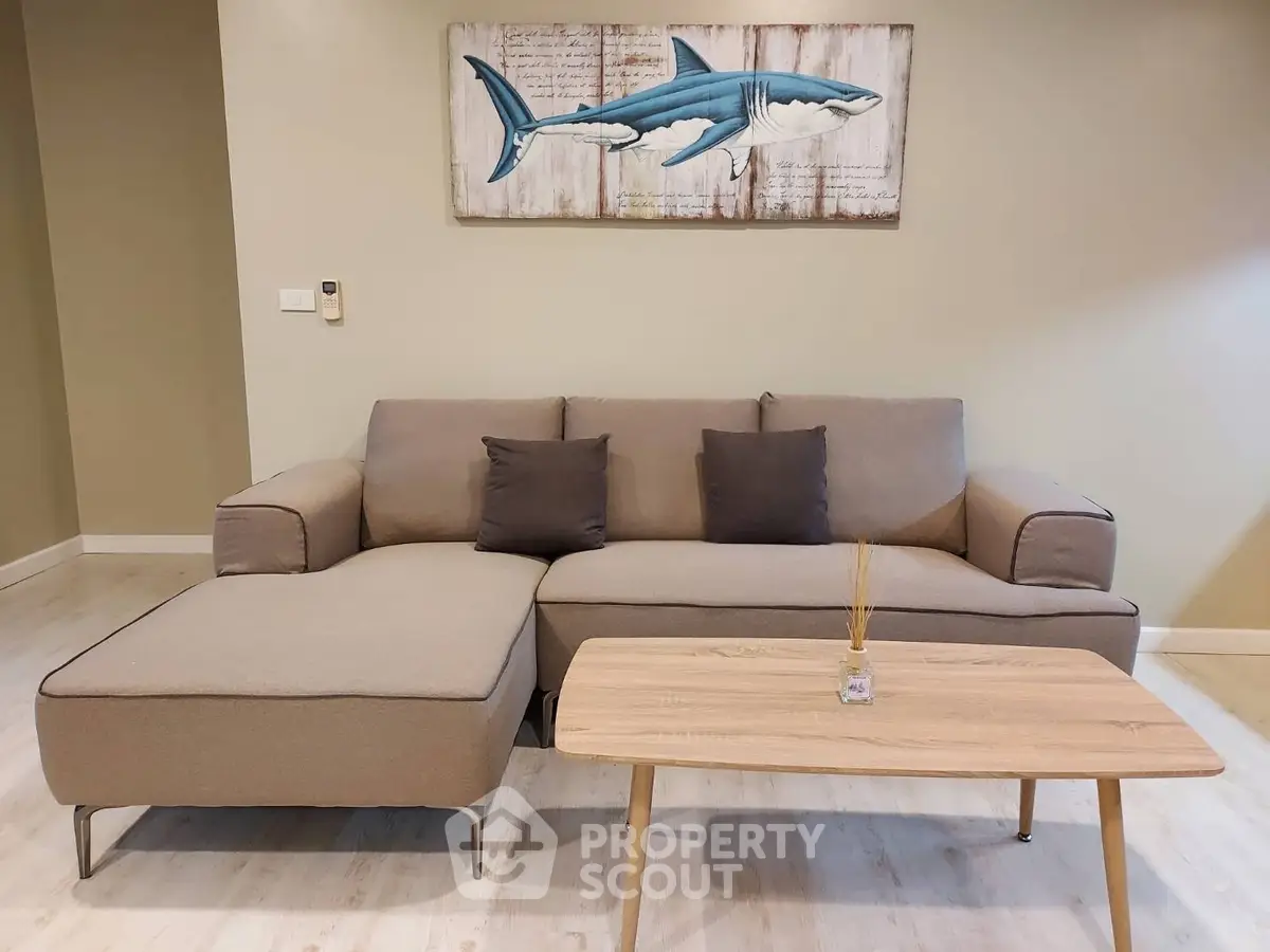 Modern living room with stylish sofa and wooden coffee table, featuring shark artwork on the wall.