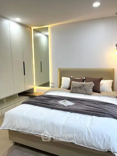 Modern bedroom with cozy lighting and stylish decor, featuring a comfortable bed and sleek wardrobe.