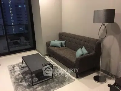 Modern living room with stylish sofa and floor lamp, featuring a cozy rug and city view.