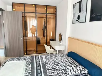 Stylish bedroom with designer bedding and mirrored wardrobe in modern apartment.