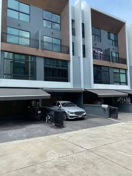 Modern townhouse exterior with carport and sleek design, showcasing contemporary urban living.