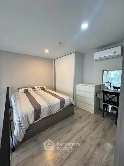 Cozy bedroom with modern decor, featuring a comfortable bed, sleek flooring, and ample natural light.