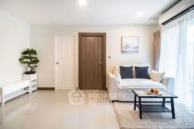 Modern living room with sleek design, featuring a cozy sofa, stylish coffee table, and large window for natural light.
