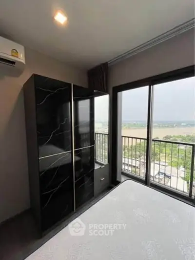 Modern bedroom with large window offering stunning view of the landscape.