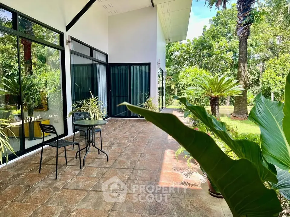 Charming garden patio with lush greenery and modern outdoor seating.