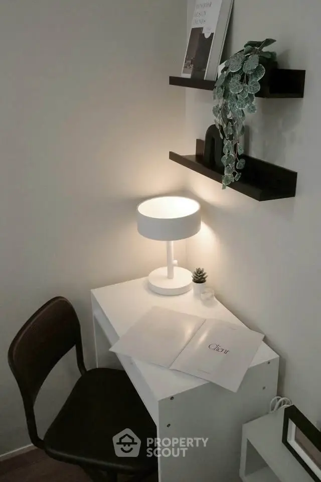 Cozy study nook with modern desk, lamp, and shelves in a stylish apartment.