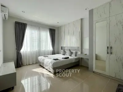 Spacious modern bedroom with elegant decor and ample natural light