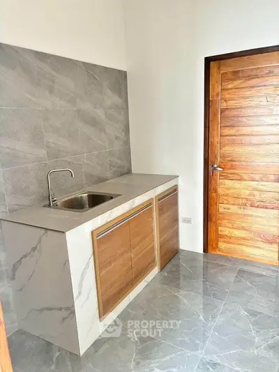 Modern kitchen with sleek marble countertops and wooden cabinetry