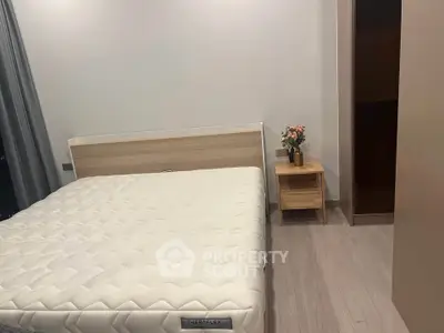 Modern bedroom with minimalist design featuring a comfortable bed and stylish nightstand.