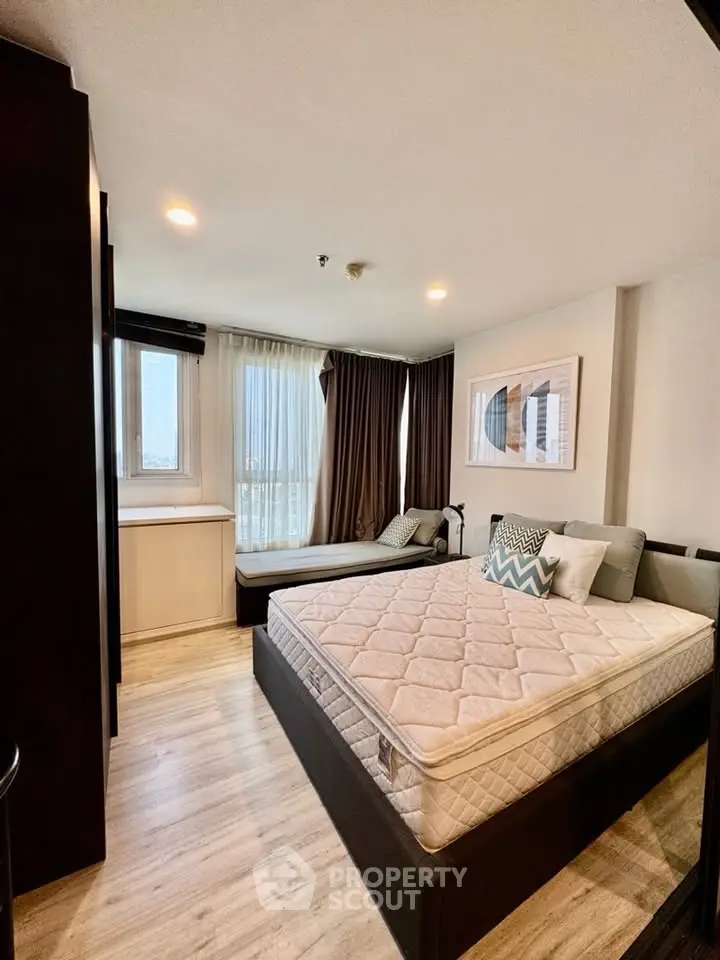 Modern bedroom with stylish decor and large window offering natural light