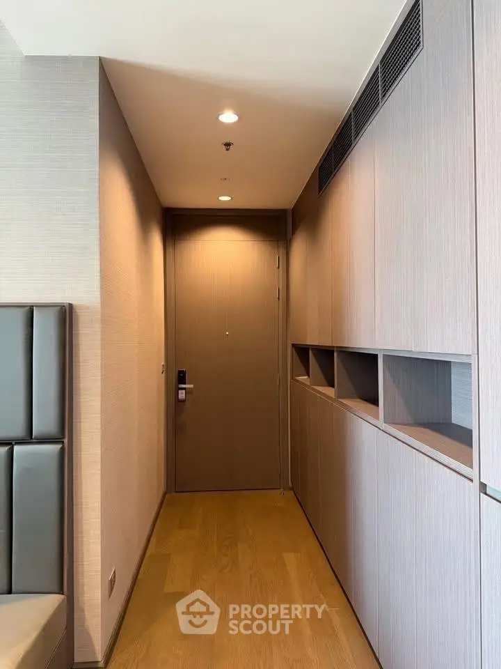 Modern apartment hallway with sleek wooden cabinetry and elegant design.