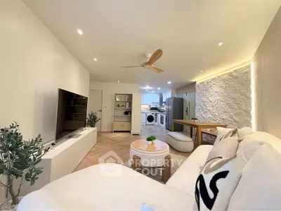Modern open-plan living room with stylish decor and kitchen appliances.