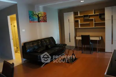 Modern living room with sleek black leather sofa and stylish shelving unit