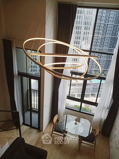 Modern duplex apartment with floor-to-ceiling windows and stylish lighting overlooking cityscape.