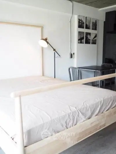Modern minimalist bedroom with natural wood bed frame and stylish lamp
