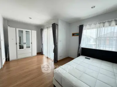 Spacious bedroom with large windows and modern furnishings