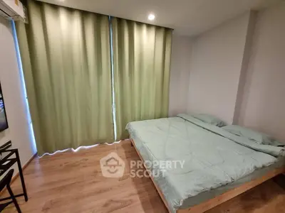 Cozy bedroom with wooden flooring and green curtains