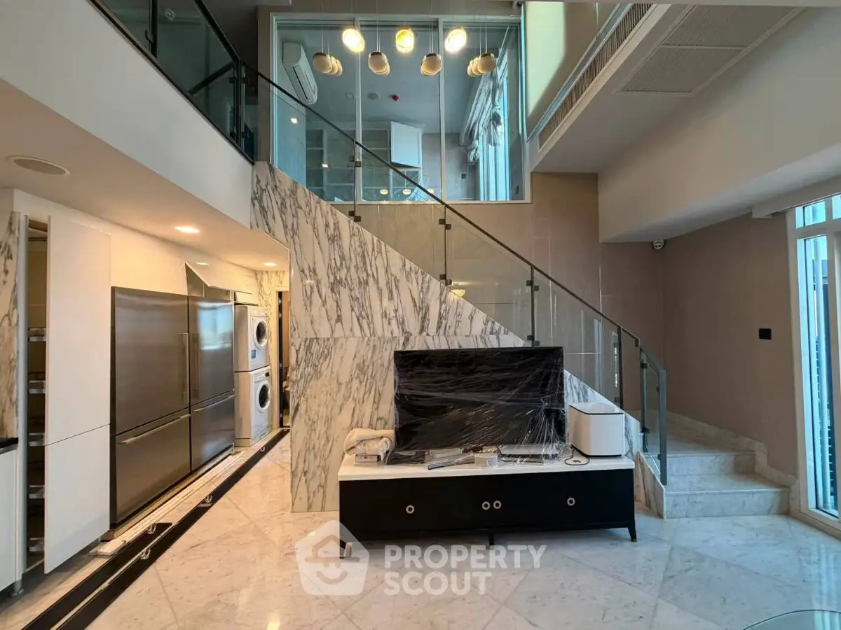 Luxurious modern living room with marble staircase and high-end appliances