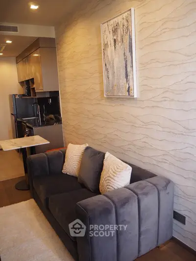 Modern living room with plush sofa and stylish kitchen in open layout apartment.