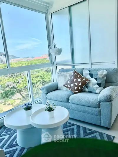 Bright living room with cozy sofa and scenic view through large windows.