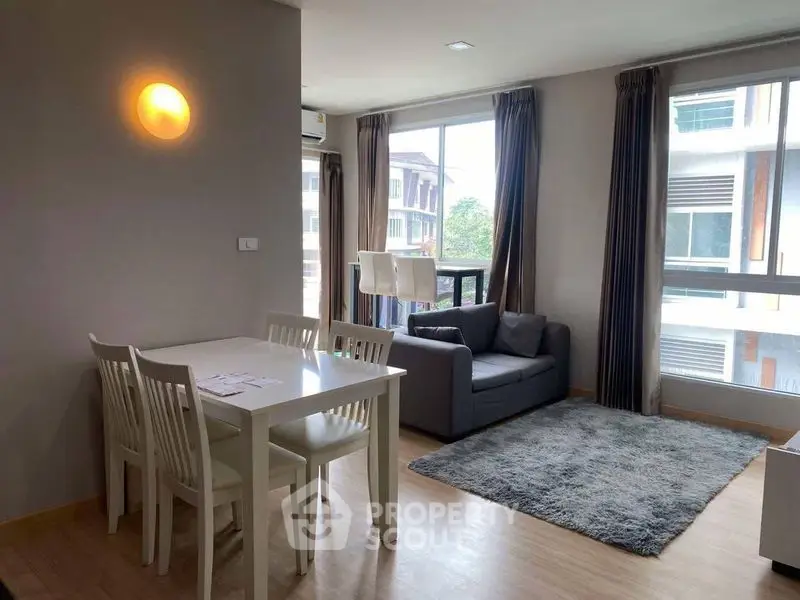 Modern living room with dining area and large windows in a stylish apartment.