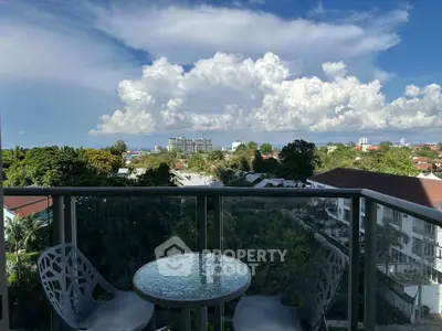 Stunning balcony view with modern seating overlooking lush greenery and cityscape.