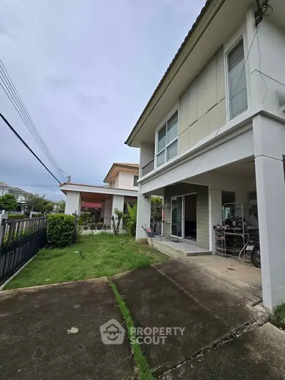Modern two-story house with driveway and garden in a suburban neighborhood.