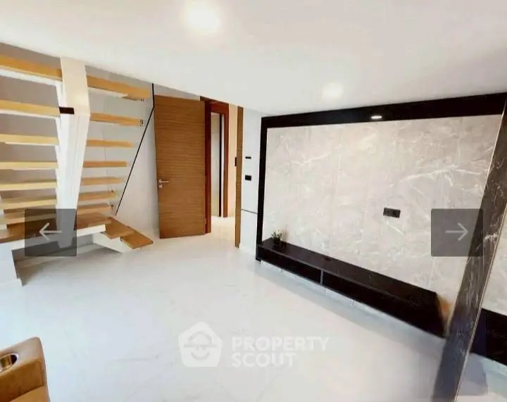 Modern interior with sleek staircase and marble accent wall in a contemporary home.