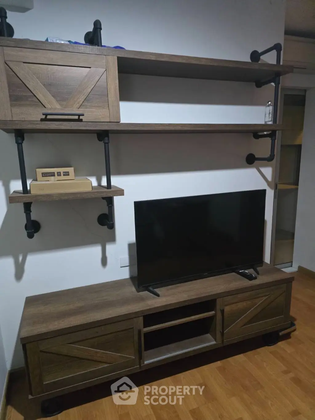 Modern living room with stylish wooden TV stand and shelves, perfect for contemporary homes.