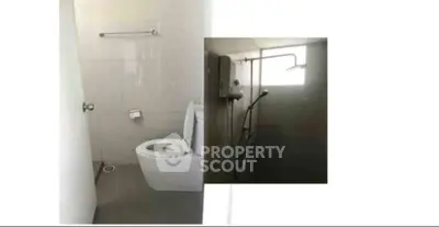 Modern bathroom with shower and toilet in minimalist design.