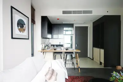 Modern open-plan living room and kitchen with stylish decor and breakfast bar seating.