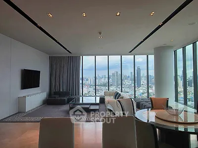 Luxurious living room with panoramic city view and modern furnishings in high-rise apartment.