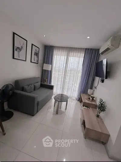 Modern living room with sleek furniture and natural light, featuring a cozy sofa and stylish decor.