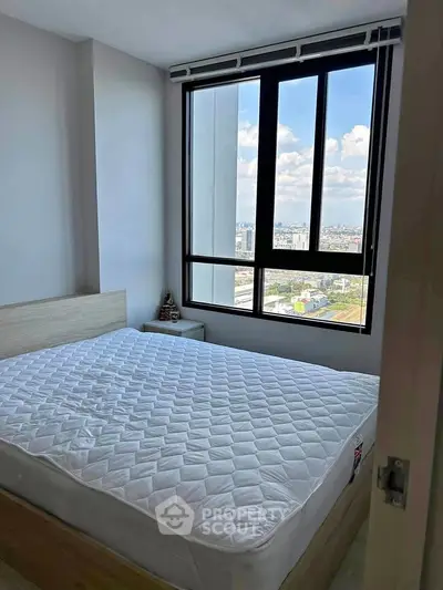 Bright bedroom with large window offering stunning city views, featuring a comfortable bed and modern decor.