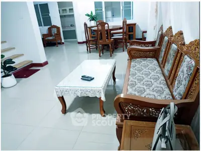 Spacious living room with elegant wooden furniture and dining area in modern home.