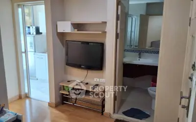 Cozy apartment interior with TV, bathroom, and kitchen view
