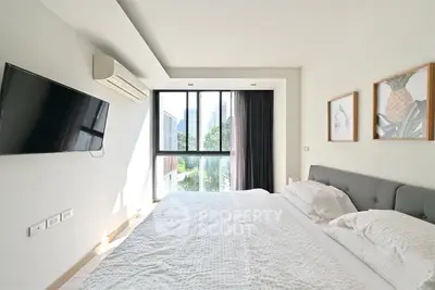 Bright and modern bedroom with large window and stylish decor in a contemporary apartment.